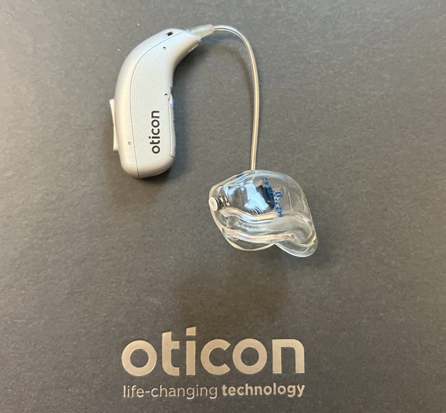 Oticon Real hearing aid sitting on top of oticon box